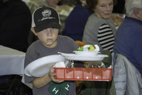 A child holding plates and a basket

Description automatically generated