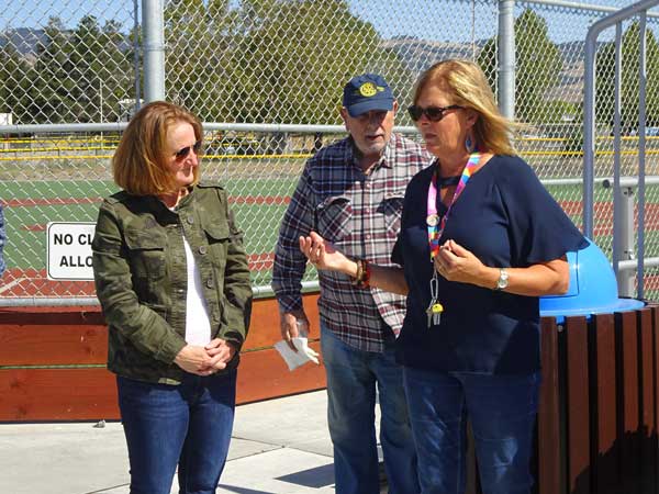 A group of people standing on a tennis court

Description automatically generated