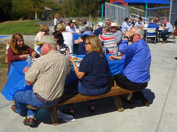 A group of people sitting at a picnic table

Description automatically generated