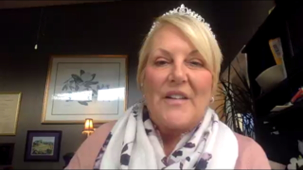 A person wearing a tiara and a scarf

Description automatically generated