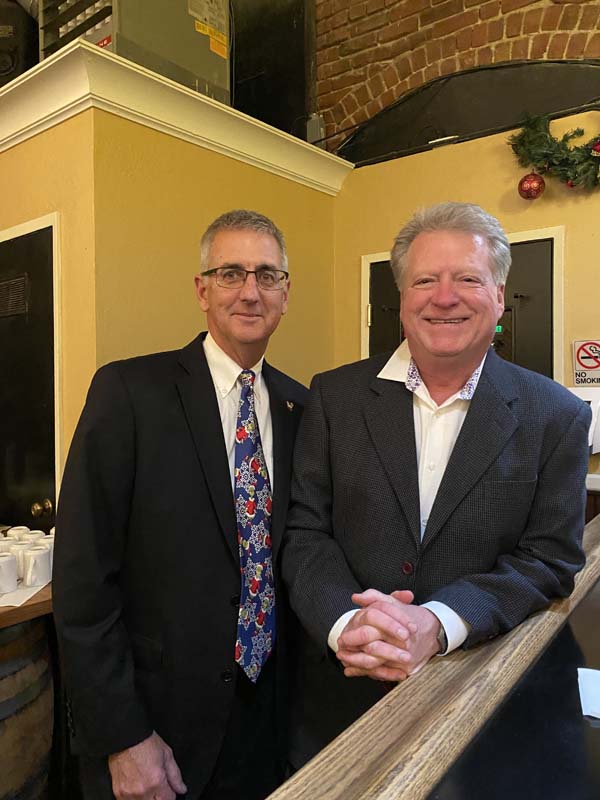 Two men in suits smiling

Description automatically generated