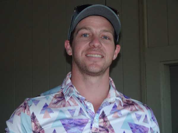 A person wearing a hat and a colorful shirt

Description automatically generated