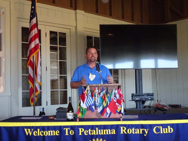 A person standing at a podium with flags

Description automatically generated