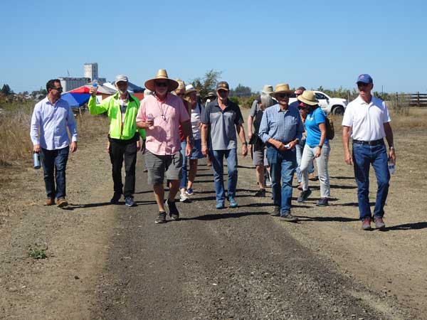 A group of people walking on a dirt road

Description automatically generated