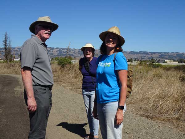 A group of people standing on a dirt road

Description automatically generated