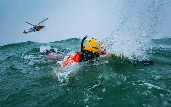 A person in a helmet swimming in the water

Description automatically generated