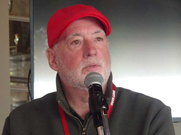 A person in a red hat with a microphone

Description automatically generated