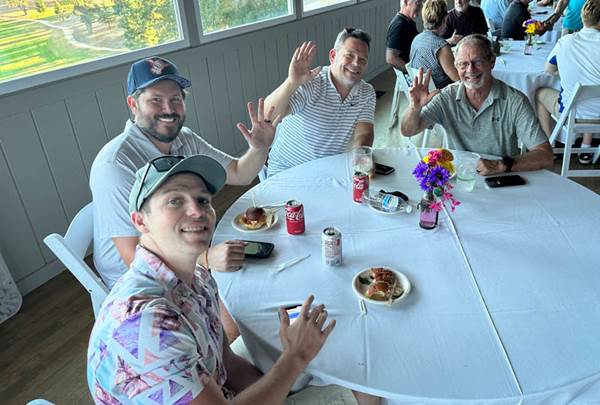 A group of men sitting at a table

Description automatically generated