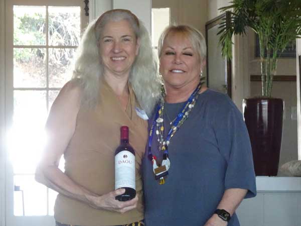 Two women holding a bottle of wine

Description automatically generated