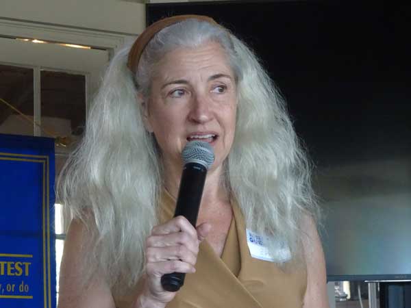 A person with long hair holding a microphone

Description automatically generated