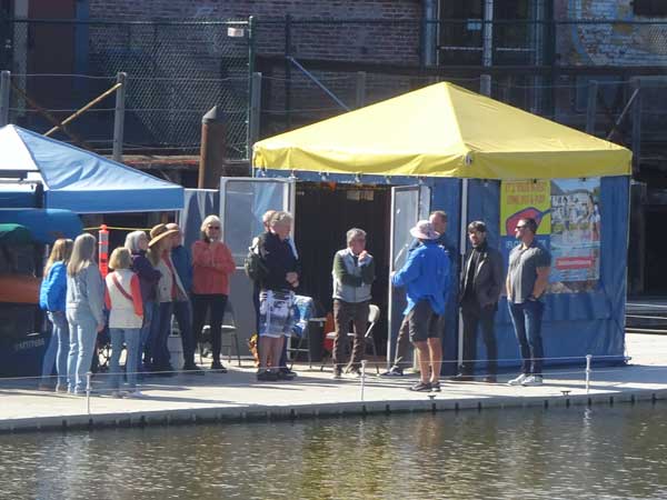 A group of people standing on a dock

Description automatically generated