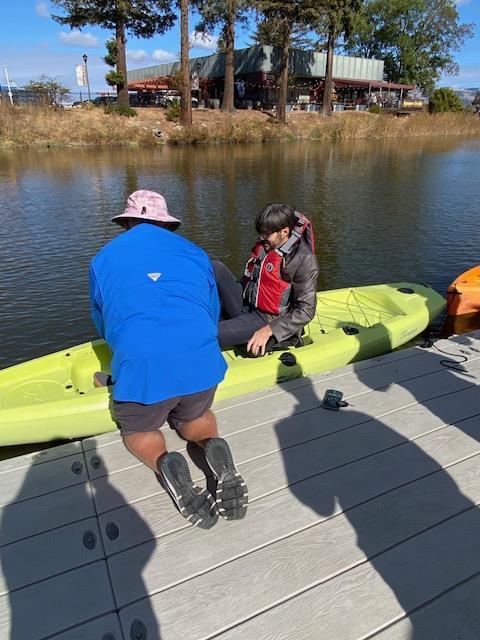 A person and child sitting on a kayak

Description automatically generated